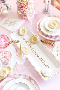 a pink table topped with plates and desserts