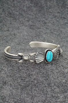 This turquoise and sterling silver bracelet was made by Navajo silversmiths Eva & Linberg Billah. The back is signed EL Billah and stamped sterling.Size: 5" (will fit up to a 6" wrist)Gap: 1"Width: 1/2"Cuff Width: 1/4"Free shipping on all orders! We ship with USPS and always include tracking. All orders ship within a day of payment.Returns are accepted up to 30 days after you receive your order. Just send us a message. Our shop offers cash back or store credit. The item must be returned in new c Western Sterling Silver Cuff Bracelet Gift, Handmade Western Sterling Silver Cuff Bracelet, Bohemian Engraved Turquoise Sterling Silver Bracelet, Western Turquoise Bracelet With Concho, Southwestern Oxidized Adjustable Jewelry, Western Turquoise Bracelets With Concho, Western Style Turquoise Bracelet With Concho, Bohemian Turquoise Engraved Sterling Silver Bracelet, Handmade Turquoise Sterling Silver Southwestern Bracelet