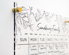 a calendar is hanging on the wall next to a coat rack with yellow knobs