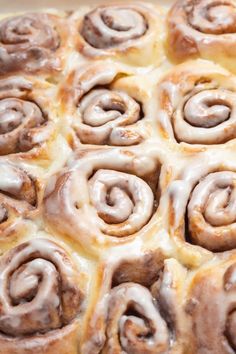 cinnamon rolls with icing sitting in a pan