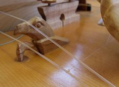 a wooden dog figurine sitting on top of a wooden table next to a piece of wood