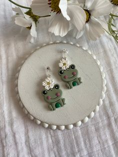 This pair of earrings is made with silver colored posts and white, yellow, green, and pink polymer clay.  This pair of earrings is perfect for anyone who loves frogs!!  If you love these earrings snatch it up before someone else does.  If you have any questions don't hesitate to contact owner and designer at HannahsJeweltique@gmail.com Visit my website at HannahsJeweltique.com Cute Nickel-free Flower Earrings, Cute Adjustable Clip-on Earrings As Gift, Cute Hypoallergenic Polymer Clay Earrings, Green Fun Earrings For Gifts, Green Fun Earrings For Gift, Fun Green Earrings For Gifts, Fun Green Earrings For Gifting, Playful Green Jewelry With Matching Earrings, White Fun Polymer Clay Earrings