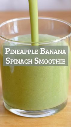 pineapple banana spinach smoothie in a glass with a green straw sticking out of it