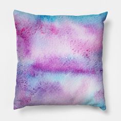 a purple and blue pillow sitting on top of a white wall