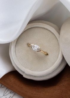 an engagement ring sits on top of a cushion