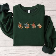 Fall Embroidered Sweatshirt Mushroom with Autumn Leaves Crewneck Embroidered Fall TShirt, Fall Top for Her, MADE IN USA There are two brands we use: Gildan and our own brand BeePro Handmade. Comfort Colors, Bella Canvas, and other brands are available upon request at a different price. If interested in adding embroidery to the sleeve please go to this listing: https://www.etsy.com/listing/1674502020 Because it is made to order, we don't accept the return or exchange unless we make a mistake We a Fall Cotton T-shirt With Floral Embroidery, Green Floral Embroidery Tops For Fall, Green Floral Embroidered Tops For Fall, Green Long Sleeve T-shirt With Custom Embroidery, Long Sleeve T-shirt With Multicolor Embroidery, Green Cotton Sweater With Embroidered Graphics, Winter Green Tops With Floral Embroidery, Green Embroidered Long Sleeve T-shirt, Green Top With Floral Embroidery For Winter