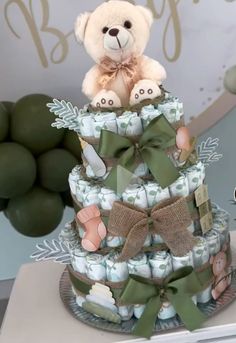 a teddy bear sitting on top of a diaper cake