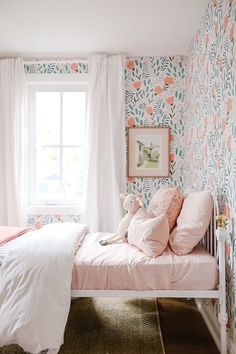 a bedroom with floral wallpaper and pink bedding