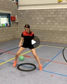 a girl is playing tennis on the court with a ball and racket in front of her