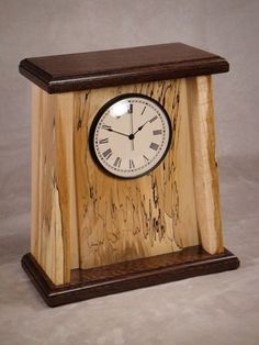 a small wooden clock with roman numerals on the face and wood grained sides