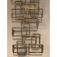 a metal wall sculpture with squares and rectangles on it's sides, against a white background