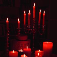 lit candles are arranged on a table in the dark