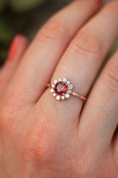 Sometimes when a girl says she likes to receive flowers as a gift, it's not the real flowers she means. Think twice and go for the safest thing - our Flora ring with Garnet and Moissanites. Floral jewelry is where it's at! Perfect as a graduation gift, birthday gift, anniversary ring or promise ring. Details: Center stone Gemstone: Garnet Stone Shape: Round Measurements: approx. 6mm Side stones Gemstone: Moissanite Shape: Round Measurements: 2mm (6), 1.5mm (6) Pictured in vermeil, available also Halo Diamond Ring For Proposal, Heirloom Cluster Ring Gift, Cluster Rings With Center Stone As Gift, Cluster Rings With Center Stone For Gifts, Cluster Ring With Halo Design For Gift, Heirloom Cluster Jewelry As Gift, Heirloom Cluster Jewelry For Gifts, Heirloom Cluster Jewelry Gift, Flower Shaped Cluster Ring Gemstone For Promise