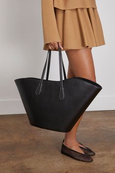 The Little Liffner Open Tulip Tote Large is a twist on a classic. This tote bag features a unique sculptural silhouette with an open top and roomy interior. Tote bag Shoulder straps Open top Snap button closure Internal zip pocket Made in Italy Leather Modern Bucket Bag With Rolled Handles For Shopping, Elegant Bucket Bag With Rolled Handles For Travel, Black Structured Bag With Leather Handles, Chic Travel Bucket Bag With Rolled Handles, Classic Structured Shopping Bag, Chic Structured Bags With Removable Pouch, Chic Bucket Bag With Handle Drop For Shopping, Modern Structured Bags With Handles, Modern Structured Bag With Handles