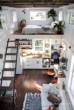 the interior of a tiny house with stairs leading up to an upper level bed and kitchen