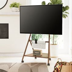 a flat screen tv sitting on top of a wooden stand