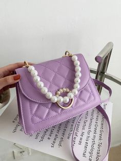 A fashionable small quilted square bag. It includes a removable top handle made of pearls, and an adjustable crossbody strap. Made of PU leather. Product Measurements: Bag Length:         7.9 in Bag Width:      2.8 in Bag Height:          5.5 in Handle Height:    5.1 in Strap Length:      47.2 in Purple Handbags, Twilly Scarf, Purple Bag, Pearl Decor, Pearl Types, Small Quilts, Givency Antigona Bag, Womens Purses, Square Quilt