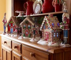 a shelf filled with lots of gingerbread houses on top of wooden shelves next to a window