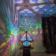 a room with many colorful lights projected on the walls and ceiling, including a stained glass lantern