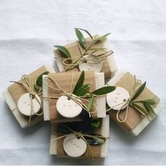 several wrapped presents are tied with twine and some green leaves on top of them