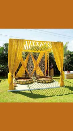 an outdoor wedding ceremony with yellow drapes and curtains on the outside, surrounded by grass