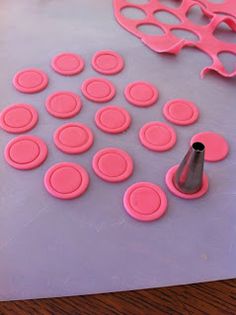 pink plastic buttons and cutters on a table