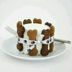 a white plate topped with a cake covered in frosting and dog paw print on it