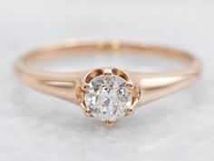 a close up view of an engagement ring with a white diamond in the center and gold accents