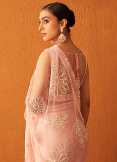 Featuring a beautiful blush pink net saree embellished with heavy pearl and crystal floral buttis all over and frill work on the border. Paired with a deep V-neck bustier with pearl and sequin linear pattern work. This sleeveless bustier has a tie-up with pearl tassels at the back.Composition : Saree: Net, Blouse: GeorgetteCare: Dry Clean Only and Vacuum Storage All products can be customised for sleeves, length of blouse and neck design Delivery : 4-6 weeks as the product is hand crafted. Check Size Guide or choose MySize for free customisation (All Sizes above XL can be made at 15% additional cost) For more information and sizes please contact fabiliciousfashion@gmail.com or visit our Copenhagen studio.About the Designer : Angad Singh's journey in the world of fashion started with at an Elegant V-neck Choli With Mirror Work, V-neck Lehenga With Mirror Work For Wedding, Reception Blouse Piece With Mirror Work V-neck, Reception V-neck Blouse Piece With Mirror Work, Bollywood Style Wedding Pre-draped Saree With Lace Work, Lace Choli With Sheer Dupatta For Party, V-neck Wedding Choli With Mirror Work, V-neck Pre-draped Saree For Diwali Wedding, Semi-stitched Lace Work Pre-draped Saree For Wedding