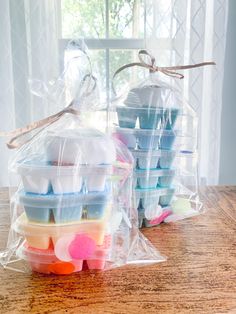 several plastic containers filled with different types of soaps on a table next to a window