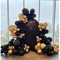 an arrangement of black and gold balloons in the shape of a man's head