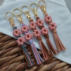 four keychains with flowers on them are sitting in a basket next to a napkin