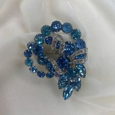 I received this fabulous vintage signed Eisenberg brooch in a lot of estate jewelry. A few the original Swarovski prong set rhinestones were discolored. After a cleaning, the rhodium plated brooch had a few of its rhinestones replaced with vintage Swarovski crystals.    The pin mechanism is in good working order.   This is a gorgeous statement piece which will dress up any outfit. Vintage Rhinestone Brooches For Vintage Events, Retro Wedding Brooches With Rhinestones, Blue Costume Jewelry Brooch For Wedding, Vintage Crystal Brooches For Formal Occasions, Antique Blue Brooches For Anniversary, Vintage Rhinestone Brooches For Anniversary, Vintage Blue Brooches With Rhinestones, Vintage Crystal Brooches For Anniversary, Vintage Brooches With Sparkling Stones As Gift