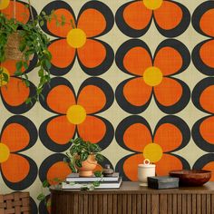 an orange and black flower wallpaper with potted plants on it in front of a wooden cabinet