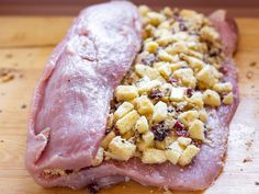 two pieces of meat sitting on top of a wooden cutting board