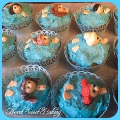 cupcakes with blue frosting decorated as children in the water