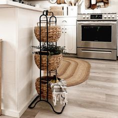 a kitchen with white walls and flooring has three baskets on the wall as well as an oven