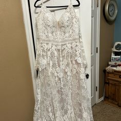 a white dress hanging on a hanger in front of a door with a clock