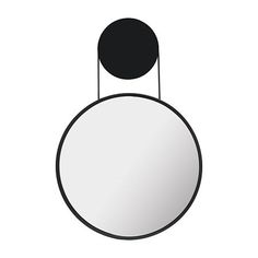 a black and white circular mirror hanging from a hook on the side of a wall