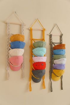 three hats hanging from hooks on a wall