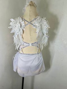 a mannequin with white feathers and beadings on it's back