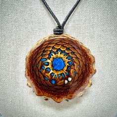 Connect with Nature's Beauty and Sacred Geometry! You are viewing a Knob Pinecone Necklace- a harmonious blend of organic charm and spiritual significance. Handcrafted with genuine knob pinecones, this necklace showcases the intricate details and natural beauty of the forest. The pinecone's earthy texture evoke the serenity of the woods, while it's spiral pattern embodies the sacred geometry of the universe. All sealed in a layer of crystal clear epoxy to preserve these one of a kind artworks of nature. The pictures you are viewing is the item you will receive. I use a brown cotton cord that can be adjusted in length using the double knotting method.  These are sealed and water resistant but not recommended to be submerged in water for long periods of time. Adjustable Blue Nature-inspired Necklace, Blue Adjustable Nature-inspired Necklace, Artistic Blue Jewelry For Festivals, Artistic Blue Necklace For Festivals, Artistic Blue Necklaces For Festivals, Bohemian Blue Necklace With Large Pendant, Blue Round Pendant Necklace For Festivals, Blue Nature-inspired Round Pendant Necklace, Third Eye Mandala