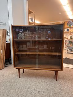 an old wooden bookcase with glass doors in a store