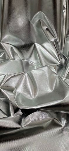 a shiny silver metallic fabric with folds