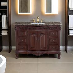 a bathroom vanity with two sinks and mirrors