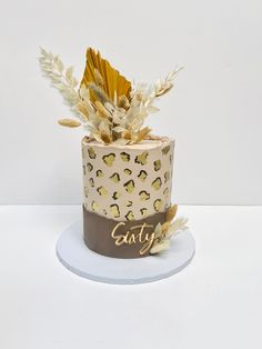 a cake decorated with gold leaves and feathers