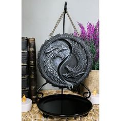 a metal plate with a dragon on it sitting on a table next to some books