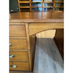 a wooden desk with drawers and shelves in the background