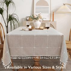 a dining room table with two chairs and a vase filled with flowers