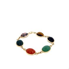 Vintage Multi Gem Scarab Bracelet in 14k Yellow Gold. This Unique and Uber Cool Link Bracelet is Sure to be the Star of Any Wrist Stack. Carved on Both Sides of the Stones, Add a Pop of Color and Texture to Your Jewelry Collection. Onyx, Tigers Eye, Aventurine, Carnelian, Bloodstone, Rhodonite. Measuring Approximately 16mm x 12mm Each.  7.375 Inch Length Stamped and Authenticated 14k Yellow Gold 15.3 Grams Fine Jewelry Bracelet With Cabochon, Fine Jewelry Cabochon Bracelets As Gift, Formal Cabochon Bracelet Jewelry, Yellow Gold Cabochon Bracelet As Gift, Yellow Gold Multi-stone Oval Bracelets, Yellow Gold Oval Bracelet With Multi-stone, Yellow Gold Multi-stone Oval Bracelet, Yellow Gold Oval Multi-stone Bracelet, Gold Cabochon Bracelet In Fine Jewelry Style